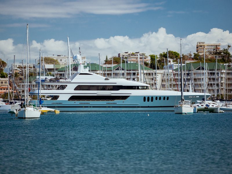 Grand yacht à moteur à coque bleu clair amarré parmi les voiliers de la marina Port du Sud
